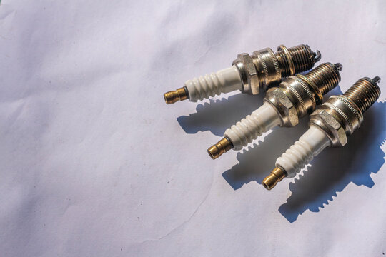 Set of Three Used Spark Plugs Positioned for Mechanical Inspection