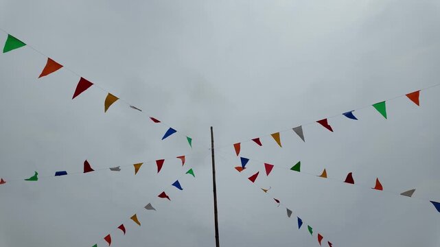 Colorful Triangular Flags Decoration in Outdoor Sky Festive Celebration with Vibrant Colors and Cheerful Atmosphere Amidst Clouds for Perfect Party.