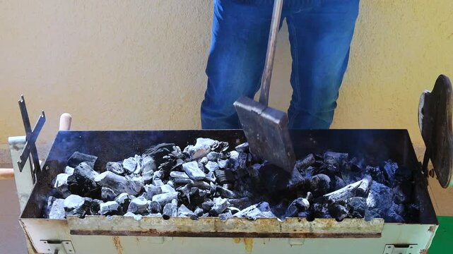 Close-up of charcoal being prepared for a traditional Greek barbecue. Coals arranged and heated to create the perfect cooking fire for grilling meat. Ideal for Mediterranean cooking content.