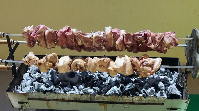 Close-up of charcoal being heated for barbecue cooking, showing coals gradually reaching cooking temperature. Essential BBQ preparation technique for outdoor grilling.