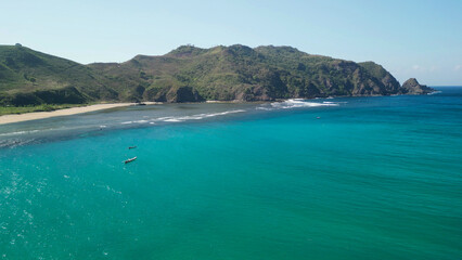 Obraz premium Aerial drone view of Mawun Beach Lombok Indonesia featuring turquoise horseshoe bay curved white sand shoreline and green hills