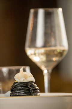 Gourmet presentation of Italian spaghetti with squid ink served on a restaurant table. 