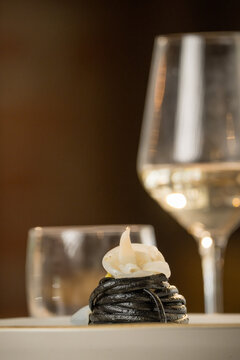 Gourmet presentation of Italian spaghetti with squid ink served on a restaurant table. 