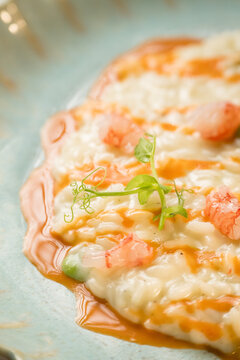 Gourmet presentation of a traditional Italian seafood risotto served on an elegant restaurant plate. The image captures the rich, creamy texture of the perfectly cooked rice beautifully combined with 