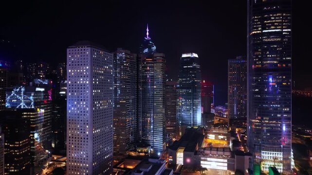 Financial District in Downtown. Futuristic Skyline At Night. Illuminated Hong Kong Cityscape Featuring Glowing Skyscrapers Rising Against Dark Evening Sky, Showcasing Modern Architectural Design And