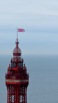 Portrait aerial drone view footage of top of the Blackpool Tower in Blackpool Lancashire England during April showing the famous seaside landmark