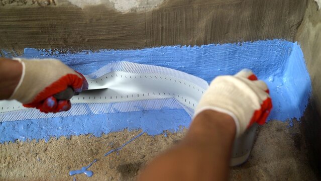 Worker Applying Blue Waterproofing Sealant