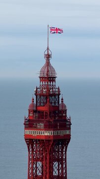 Portrait aerial drone view footage of top of the Blackpool Tower in Blackpool Lancashire England during April showing the famous seaside landmark