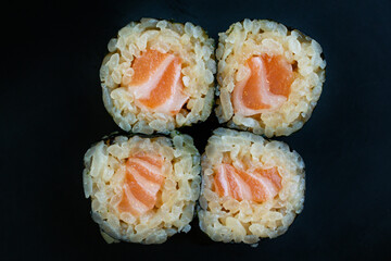 Salmon Sushi Roll Cut Pieces Close Up, Salmon Maki Sushi Rolls on Dark Background Top View, Fresh Salmon Roll Sushi Bite Size © น้าหนอน