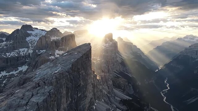 Sunrise over rugged mountain peaks with snow and rocky cliffs