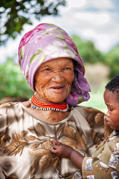 portrait of an Elderly San Woman with Young Children in Rural Botswana
