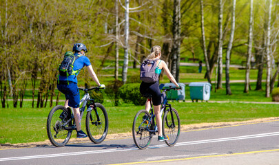 Fototapeta premium Cyclists ride on the bike path in the city Park 