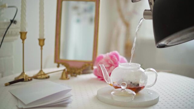 Aging paper with tea. Glass teapot with tea bags poured with boiling water on elegant table, interior decor for cozy home settings, crafts