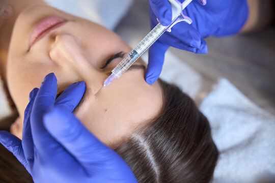 Caucasian woman receiving injection at beauty clinic