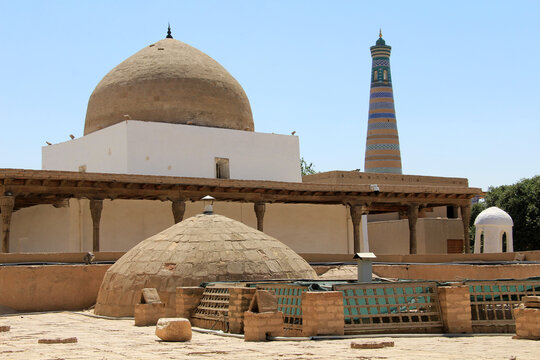 Historical structures within Khiva Fortress. The brick and tile decorations on the domed buildings are noteworthy. Khiva, Uzbekistan.