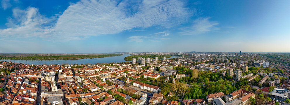 Aerial view of the historic Zemun district featuring red-tiled rooftops, green parks, and the Danube river under a blue sky Belgrade, City of Belgrade, Serbia.