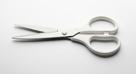 Obraz premium White scissors on a white surface with overhead lighting and copy space