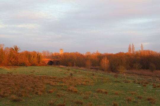 Cinematic golden hour, soft light sunset in fall outdoor nature countryside with meadow, woods and catherdral in distant