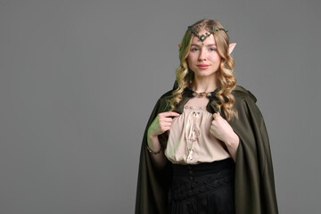 Naklejka premium Beautiful girl dressed as elf on grey background, space for text