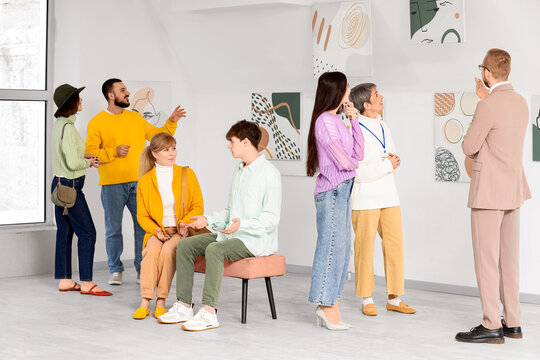 Group of people with guide at art gallery exhibition