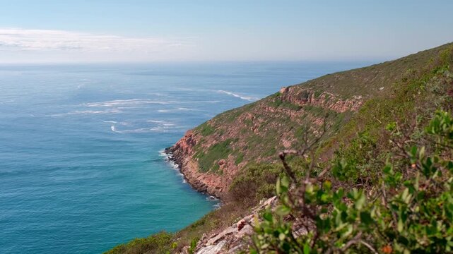 High view from hiking trail of Robberg rugged coastline and ocean at sunrise