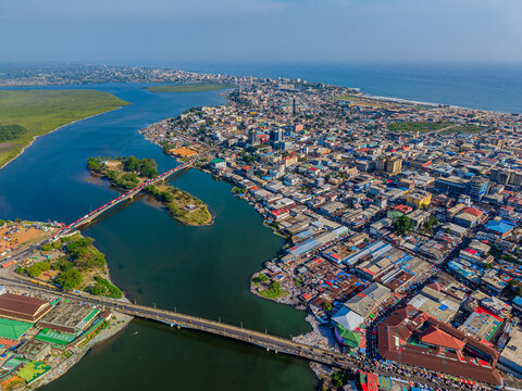 Aerial view of bridges spanning the waterways, connecting the bustling cityscape with vibrant markets and residential areas, Monrovia, Liberia.