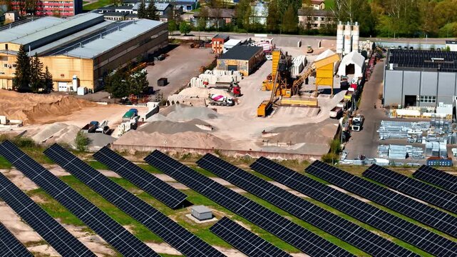 Aerial Slow Motion of Solar Panel Farm Integrated with Industrial Factory and Construction Site