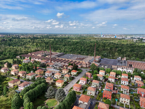 Aerial view of the historic Industrial Village of Crespi d'Adda with its factory chimneys and residential houses in Capriate San Gervasio, Lombardia, Italy.