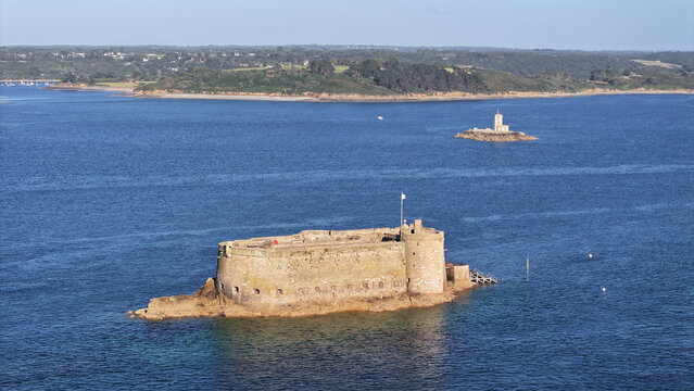 Aerial view of the imposing Chateau du Taureau standing defiant against the relentless sea, a sentinel of stone amidst the shimmering waters, Plouezoc'h, Bretagne, France.