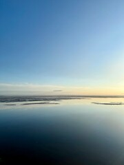 Obraz premium quiet yellow sunset sky reflection on the water surface, sea horizon, beautiful and peaceful