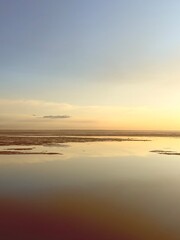 Obraz premium quiet yellow sunset sky reflection on the water surface, sea horizon, beautiful and peaceful