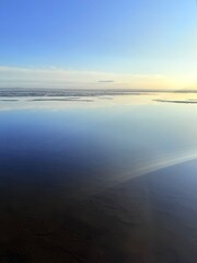 Fototapeta premium quiet yellow sunset sky reflection on the water surface, sea horizon, beautiful and peaceful