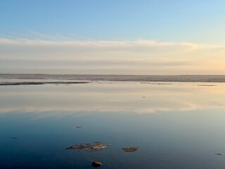 Fototapeta premium quiet yellow sunset sky reflection on the water surface, sea horizon, beautiful and peaceful