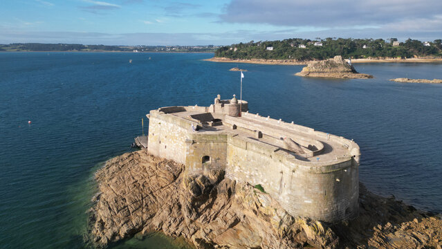 Aerial view of the formidable stone fortress of Chateau du Taureau standing proudly on a rugged islet amidst the deep blue waters, Plouezoc'h, Bretagne, France.