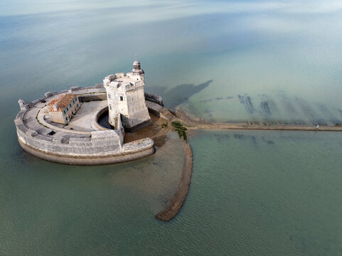 Aerial view of the historic Fort Louvois, a formidable circular stone fortress, in tranquil green-blue waters under a diffused sky, Fort Louvois, Bourcefranc-le-Chapus, France.