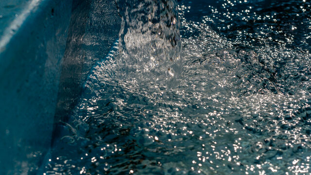 Heavy Water Stream Crashing Into A Blue Basin Creating Frothy Bubbles For Fluid Power Concepts