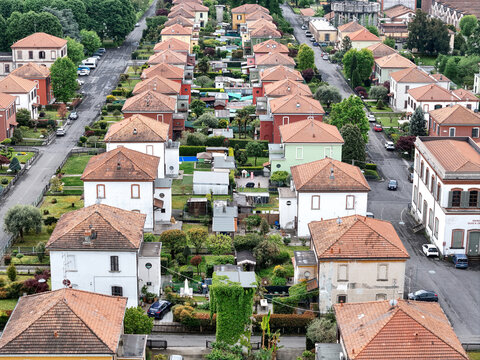 Aerial view of the Industrial Village of Crespi d'Adda with its historic rows of houses and lush gardens in Capriate San Gervasio, Lombardia, Italy.