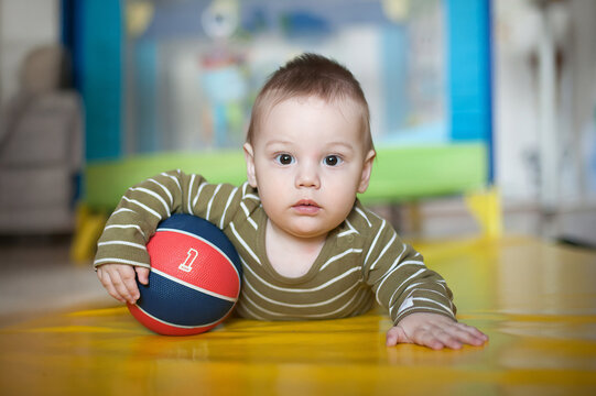 Future basketball star shows potential while exploring a colorful playroom with a very serious expression on his face