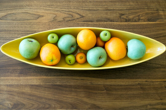 Mid century bowl with decorative fruit on wooden table