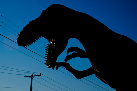 Dinosaur Skeleton Silhouette Against Blue Sky