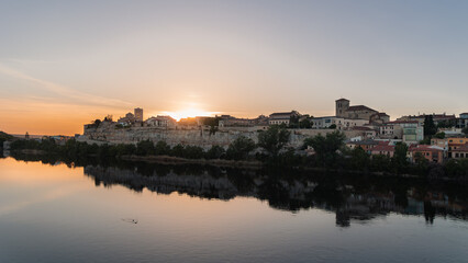 Fototapeta premium Zamora cityscape reflecting in Duero river during sunset