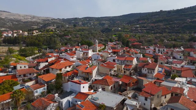 Aerial Drone Flight Over Laneia Village Stone Rooftops Towards Historic Church Cyprus
