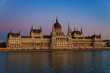 Fototapeta premium Majestic Budapest Parliament Building viewed across the Danube River at twilight blue hour. Iconic Hungarian architecture cityscape landmark.