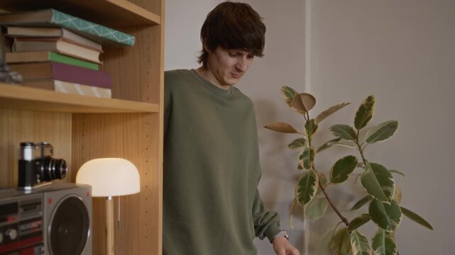 Young Caucasian man with orthopedic brace wincing in pain going to comfortable sofa to rest in living room at home