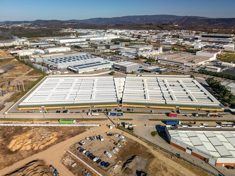 Aerial view of sprawling industrial complex with geometric roof patterns under the bright sun, Albergaria-a-Velha, Aveiro District, Portugal.