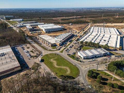 Aerial view of industrial buildings and roads, a modern landscape blending commerce with nature's backdrop, Albergaria-a-Velha, Aveiro District, Portugal.