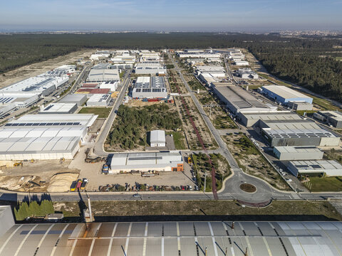 Aerial view of industrial buildings casting long shadows under a clear sky, Gafanha da Encarnacao, Aveiro District, Portugal.