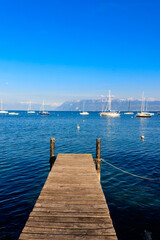 Fototapeta premium Wooden pier overlooking the Alps and Lake Geneva in Switzerland