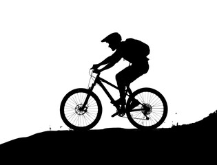 Obraz premium Silhouette of a Mountain Biker Riding Uphill at Sunset
