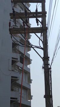 Utility lineman using hot stick to open drop out fuse on distribution power pole.